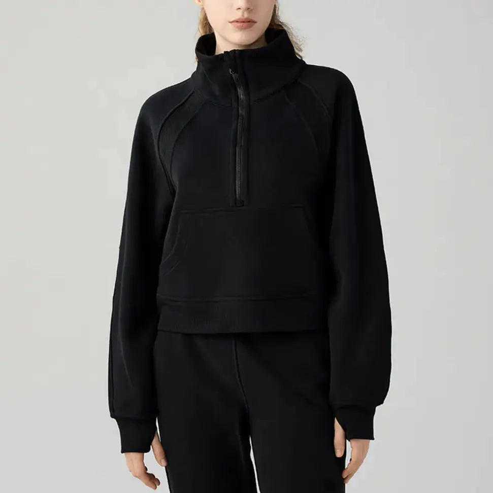 Black half-zip sweatshirt worn by a person on a gray background