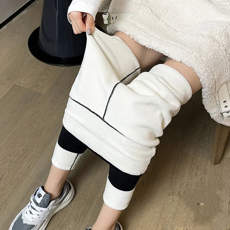 Person wearing a white fleece-lined jacket and leggings on a wooden floor.