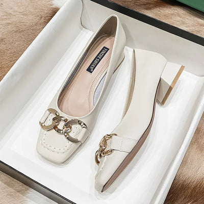 White shoes with gold chain detail on a white box