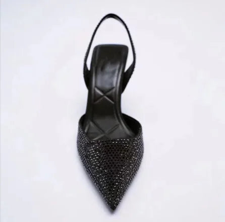 Black studded high-heeled shoe on a white background