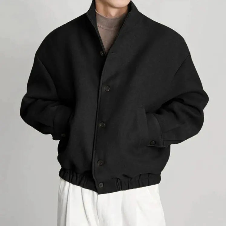 Person wearing a black jacket on a plain background