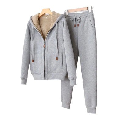 Gray hoodie and pants set on hangers against a white background