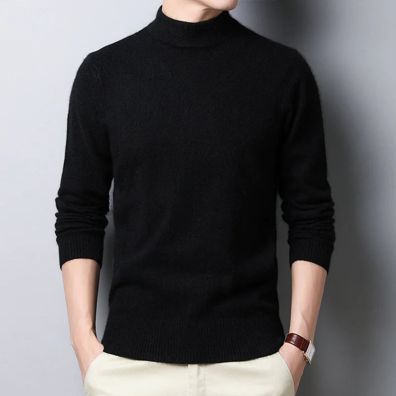 Person wearing a black turtleneck sweater against a gray background