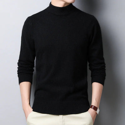 Person wearing a black turtleneck sweater against a gray background