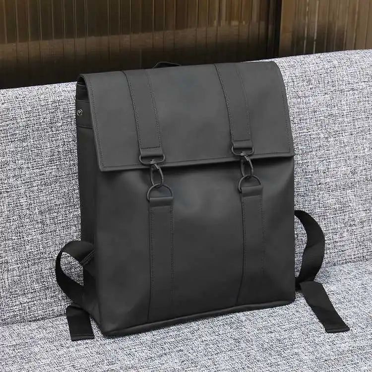 Black backpack on a textured gray surface