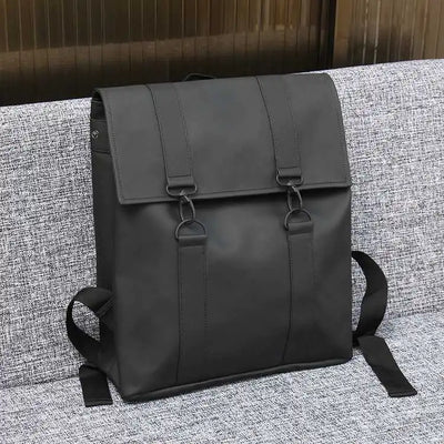 Black backpack on a textured gray surface