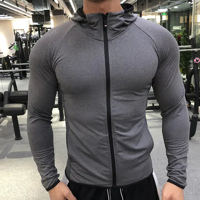Person wearing a gray athletic jacket in a gym setting