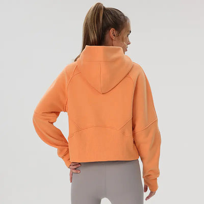 Person wearing an orange hoodie on a plain background