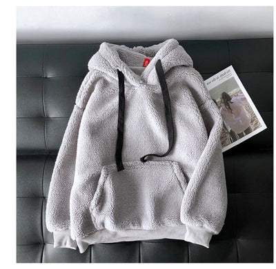 Gray fleece hoodie on a black leather couch with a magazine in the background